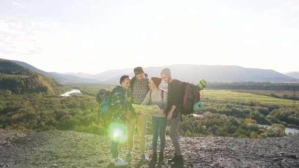 A caucasian hipsters friends using a map try to find the right way to the next destination, laughing and talking. Active lifestyle and travel concept — Stock Video
