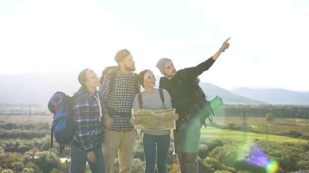 Група друзів кавказька мандрівників перевіряєте карту, намагаючись з'ясувати, як правильно на вершині гори на заході сонця. Туризм та здорового способу життя концепція. Доллі постріл — стокове відео