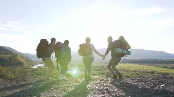 Genç turist bir grup zirve fethetti ve sevinir. Başarı, başarı ve başarı kavramı ile yürüyüş insanlar tezahürat. Gün batımında eğleniyor yürüyüşçü. — Stok video