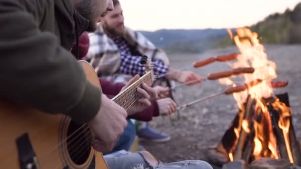 저녁에 산에 요리 소시지, 젊은 사람들과 모닥불의 피크닉. 노래와 기타 연주 쾌활 한 친구입니다. 돌리 촬영 — 비디오