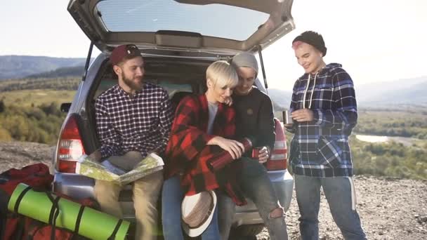 Vier Freunde ruhen sich nach langer Autofahrt aus. — Stockvideo