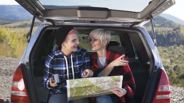 Dos amigas con taza de té relajándose en el fondo de la montaña . — Vídeo de stock