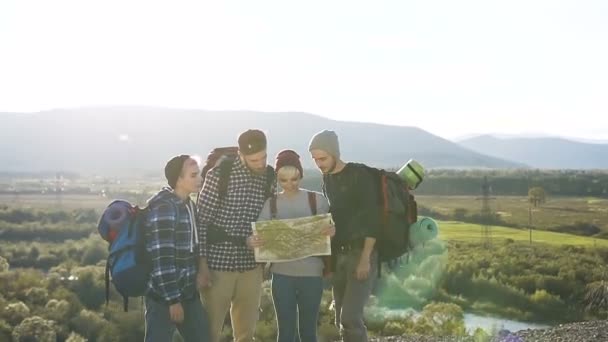 Dos parejas jóvenes usando el mapa en las montañas . — Vídeo de stock