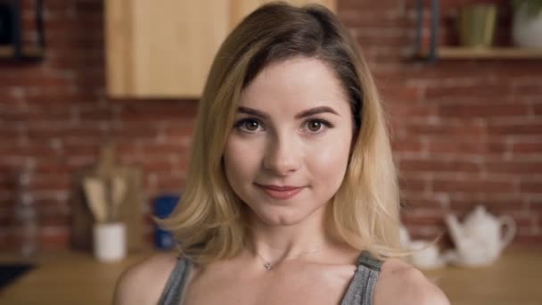 Portrait de femme en forme souriante tient bol en verre avec des légumes debout derrière la table de cuisine à la cuisine. Une saine alimentation. Dolly shot — Video