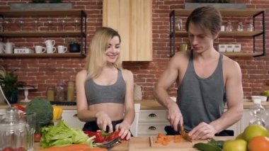 Genç çift kesme sebze salatası evde mutfakta yemek pişirmek için ahşap tahta üzerinde olduğunu. Sağlıklı gıda ve sağlıklı yaşam tarzı