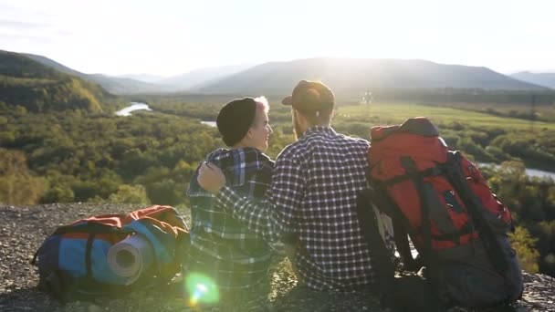 Dolly shot de mignon couple heureux assis sur le sol pendant le voyage dans la montagne . — Video