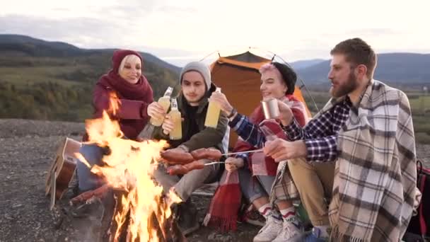 Mutlu arkadaş clining tarafından bir dağda yanıyor sosis pişirme sırasında bira grubu. — Stok video