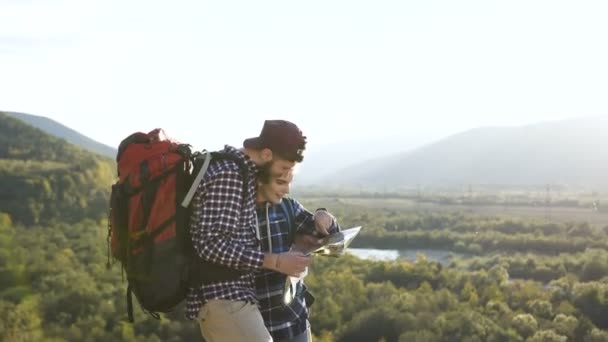 Portraitaufnahme junger Mann und Frau mit Landkarte in den Bergen. — Stockvideo