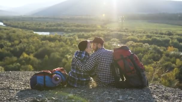 Piękna para siedzi na ziemi w góry. — Wideo stockowe