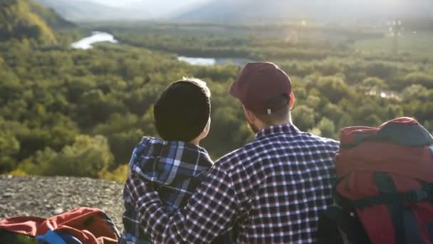 Gros plan d'un beau couple assis sur le sol dans la montagne . — Video