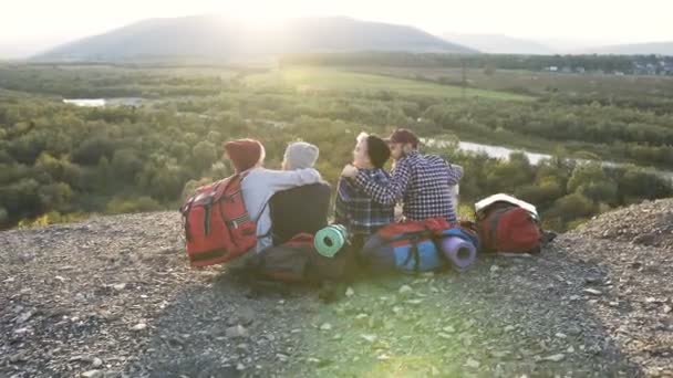 Gruppe von vier Freunden auf dem Boden im Berg sitzend. — Stockvideo