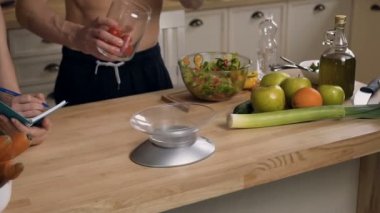 Erkek eller diyet salata pişirme için yeni bir reçete yapma tartım için elektronik ölçeklerde kiraz domates atma. Sağlıklı gıda