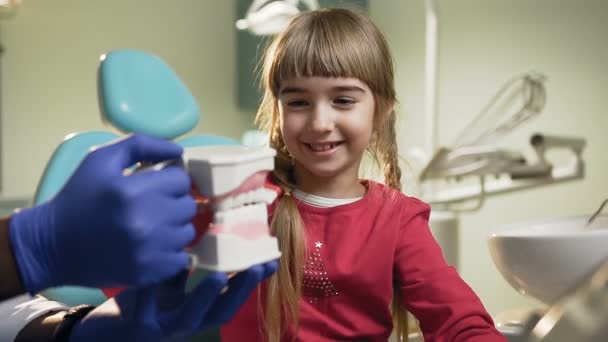 Meisje tandenpoetsen plastic in de tandarts kabinet. — Stockvideo