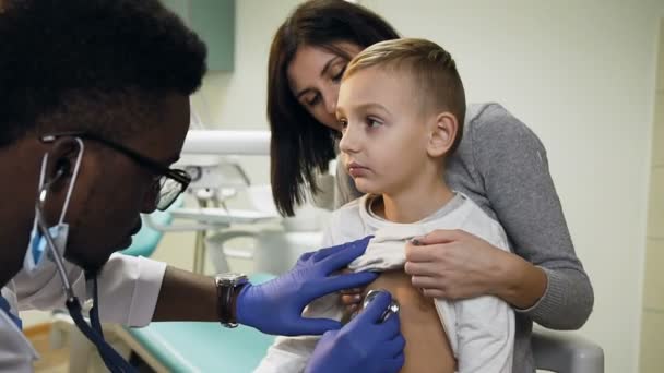 Niedliche junge Mutter und ihr kleiner Sohn beim Kinderarzt. — Stockvideo