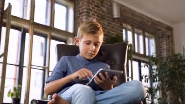 Tablet bilgisayar kullanarak sevimli beyaz çocuk. Dijital tablet üzerinde oyun genç genç çocuk. Kapalı. Eğitim, bilim, teknoloji, çocuk kavramı