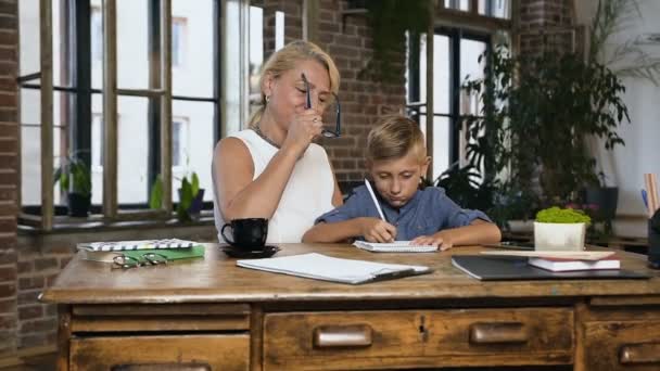 Mormor hjälper till att pojken student med en lektioner hemma i kontorsrum. Den tonåring pojken med mellersta år lärare fullgör en läxor uppgift av skolan — Stockvideo