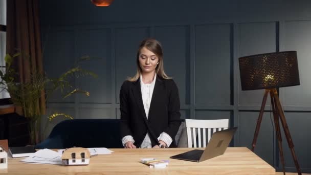 Долли снимок женщины-риелтора, сидящей за столом и отдающей ключи от квартиры на камеру . — стоковое видео