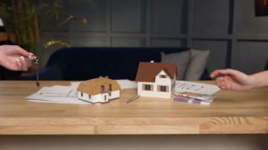 Anahtar kadın istemcilerine veren kadın emlakçı elinde kadeh yukarıya kapatmak.