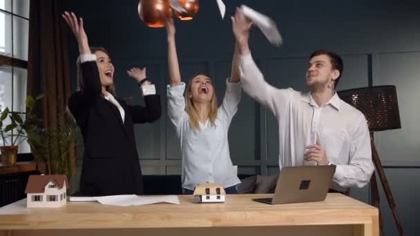 Equipo de jóvenes arquitectos tirando papel en la oficina . — Vídeos de Stock