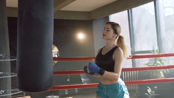 Молода жінка ударяє мішок під час тренування . — стокове відео