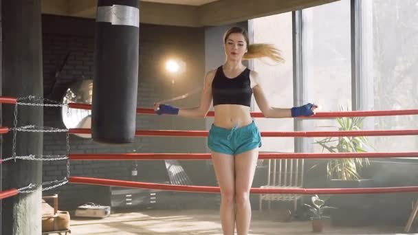 Boxer femme caucasienne sautant sur la corde à sauter dans la salle de gym . — Video