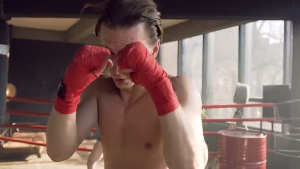 Mužský boxer, který bije ve vzduchu na kameru v tělocvičně. — Stock video