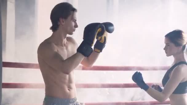 Aantrekkelijke vrouwelijke Boxer training met mannelijke coach op boksring. — Stockvideo