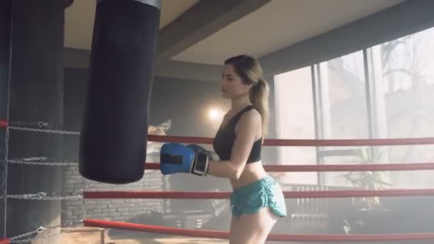 Gerichte fit vrouw slaan bokszak tijdens de training. — Stockvideo