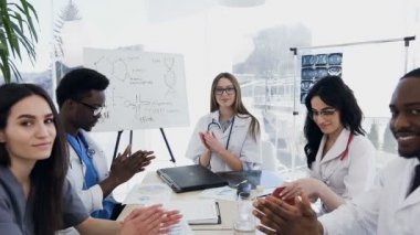 Yakışıklı beş doktorlar neşeli applauding ve kameraya bakıyor.