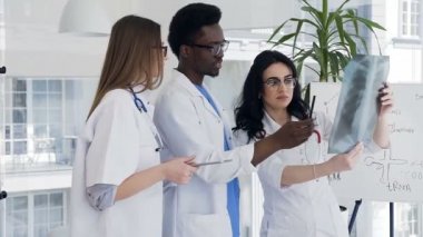 Doktor grup tartışmak x-ray modern kliniğinde.