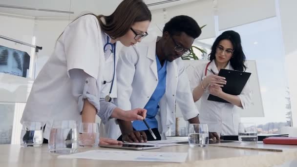 Tres médicos durante la discusión de los resultados del análisis en el hospital . — Vídeos de Stock