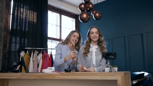 Dolly skott av två självsäkra unga kvinnor inspelning tutorial hur man väljer bra borste för smink och dela på sociala medier i hennes vlog. — Stockvideo