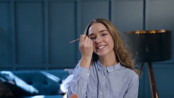 Atractiva joven mujer usando maquillaje cepillo para pintar cejas . — Vídeos de Stock