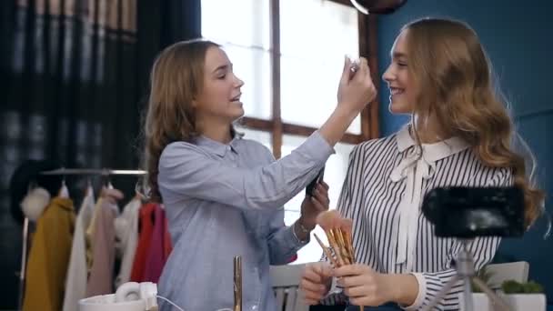 Profissional feminino maquiagem artista fazendo maquiagem para o jovem modelo bonito . — Vídeo de Stock