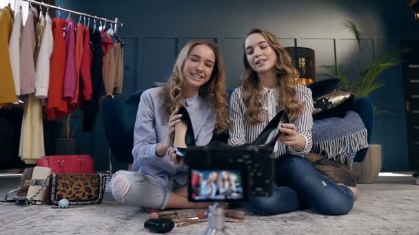 Dos bloguera de moda femenina demostrando zapatos de tendencia para hacer video blog sobre el estilo de moda . — Vídeo de stock