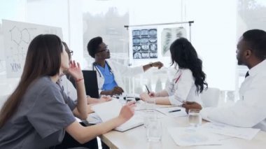 Klinikte hastanın x-ışını baskılarını tartışan profesyonel doktorların çoklu etnik grubu. Sağlık, hastane, meslek insanları, teknoloji ve tıp konsepti