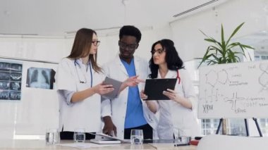 Hastane konferans odasında kan analizi hastanın sonucu tartışan çok etnik tıp uzmanları ekibi. Doktorlar tıbbi reçete tarafından hastanın daha fazla tedavi tartışmak
