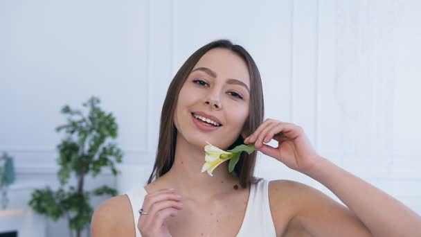 Portret strzał atrakcyjnej młodej kobiety z kwiatem. — Wideo stockowe