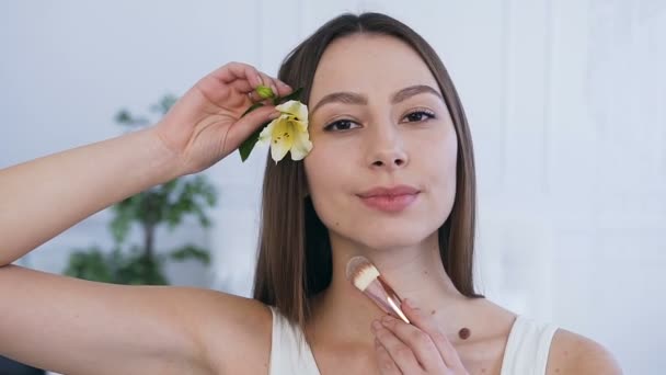 Porträtt skott av leende vacker kvinna med blomma i håret. — Stockvideo