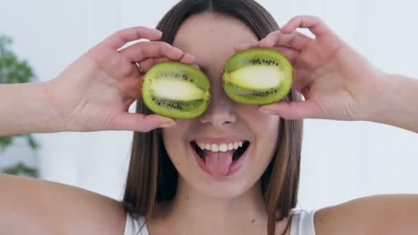 Close-up shot van aantrekkelijke gelukkige vrouw poseren met Kiwi op de ogen. — Stockvideo