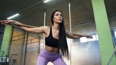 Güzel uygun kadın spor salonunda eğitim sırasında geri squat kardiyo yapıyor.
