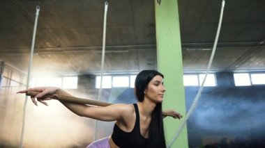 Konsantre fit kadın spor salonunda eğitim sırasında geri squat yapıyor.