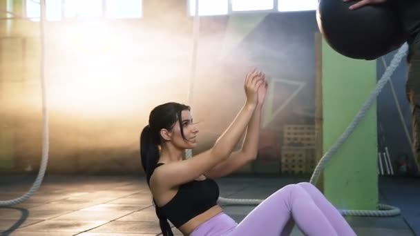 Wanita muda fit membuat latihan abs dengan aerobik bola dengan pria olahraga menarik . — Stok Video