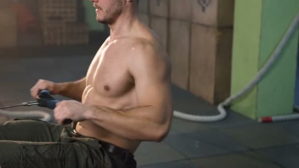 Close-up shot van aantrekkelijke fit man training terug op de sport simulator in de Gym. — Stockvideo