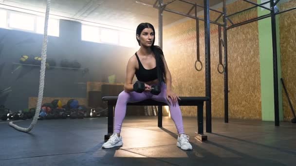 Yakışıklı uygun kadın spor salonunda dumbbells kullanarak eller eğitim. — Stok video