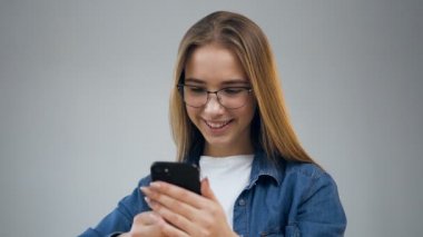 Ofiste akıllı telefon kullanan güzel genç kadın.