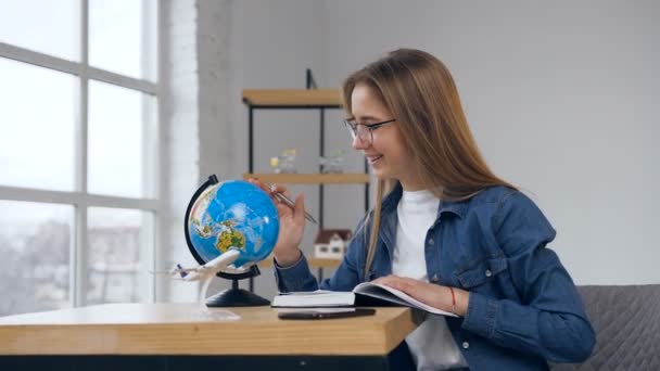 Junge kaukasische Frau mit Globus zu Hause. — Stockvideo