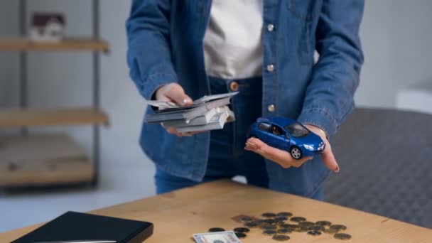 Close up shot female hands with money in one hands and toy car in another. — Stock Video