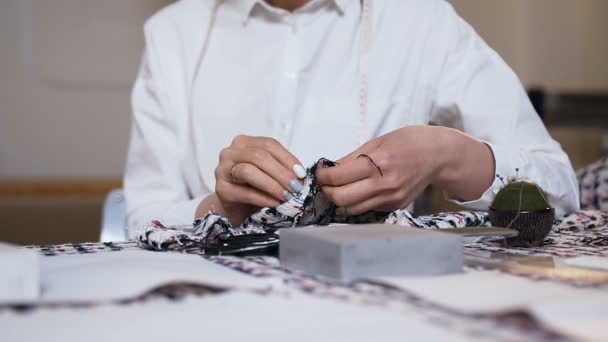 縫製スタジオで女性の仕立て屋の手が布を縫う. — ストック動画
