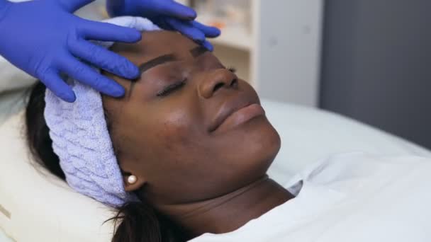 Knappe Afrikaanse vrouw tijdens cosmetische behandeling in Spa Salon. — Stockvideo